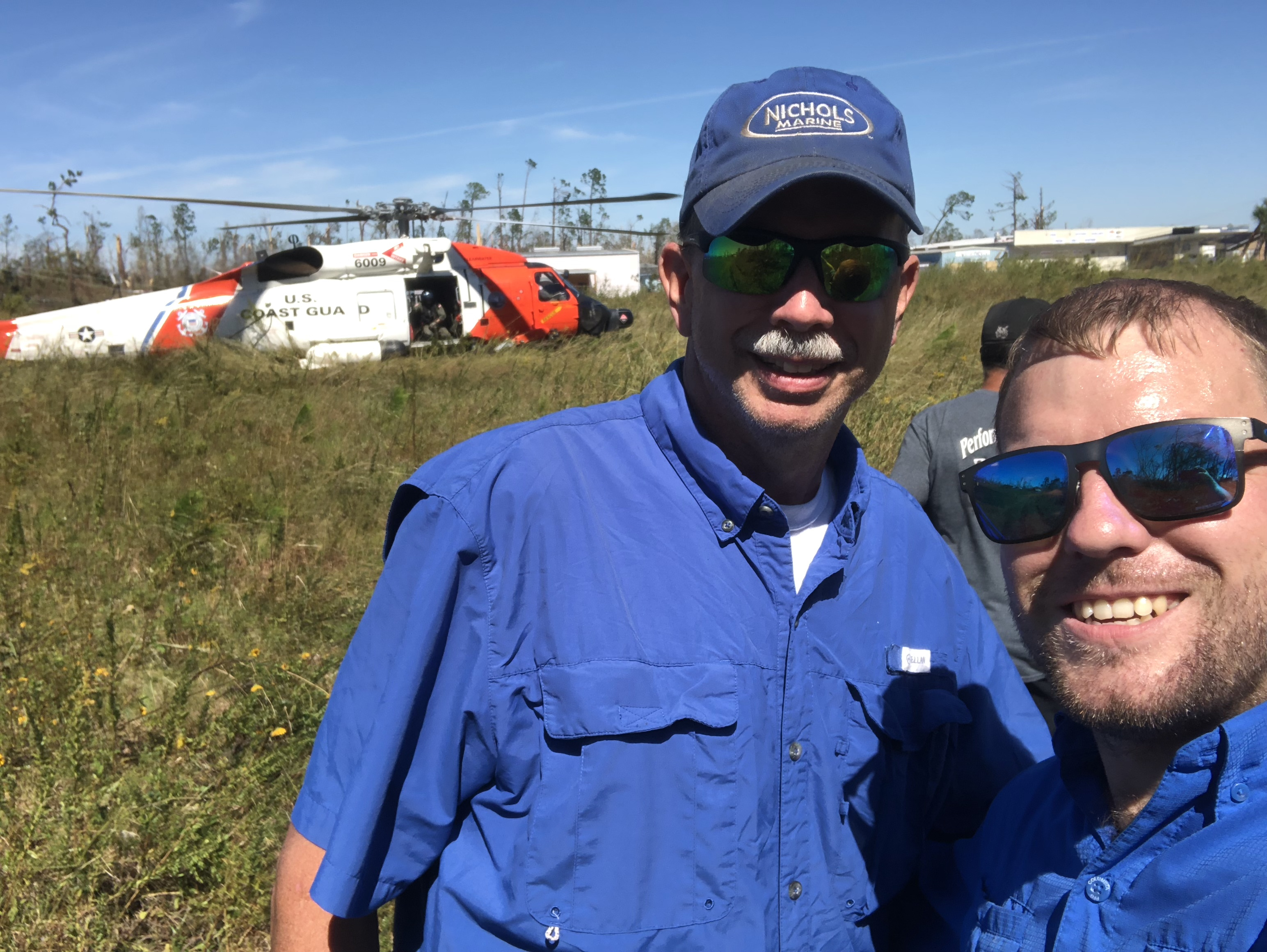 Ryan Nichols and his father with a U.S. Coast Guard MH-60 Jayhawk (6009) after Hurricane Michael, October 2018